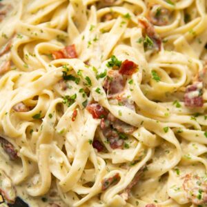 close up shot of creamy bacon pasta in large pan